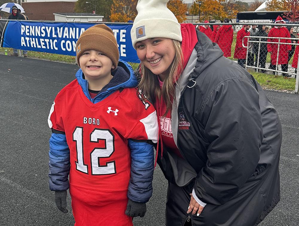 Chacen Sicignaro, pictured with his Mars Area Elementary School teacher Savannah Fischer, cheers on the Fightin Scots from the sidelines, while wearing a No. 12 jersey that was presented to him by the football team.